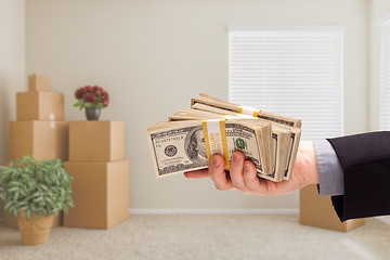 Image showing Handing Over Cash In Room with Packed Moving Boxes