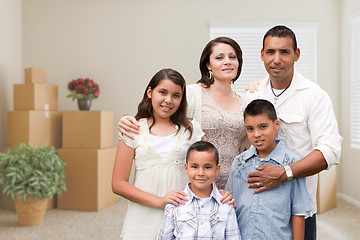 Image showing Hispanic Family in Empty Room with Packed Moving Boxes and Potte