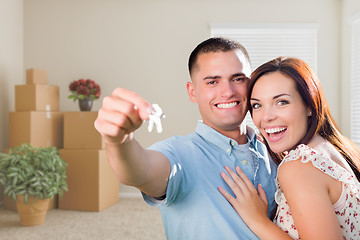 Image showing Young Military Couple with House Keys in Empty Room with Packed 