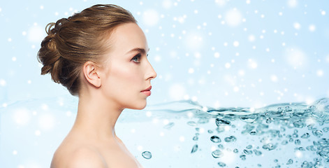 Image showing beautiful young woman face over water and snow
