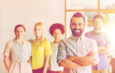 Image showing happy young man over creative team in office