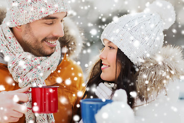 Image showing happy couple with tea cups over winter landscape