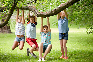 Image showing happy kids hanging on tree in summer park