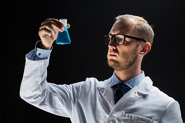 Image showing young scientist holding test flask with chemical