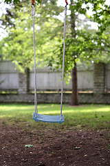 Image showing empty wooden swing hanging in summer garden