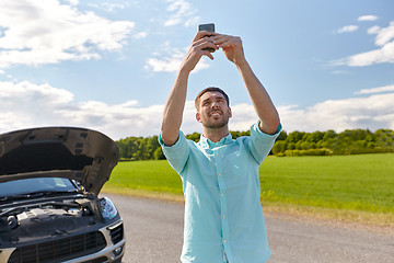 Image showing man with smartphone and broken car at countryside