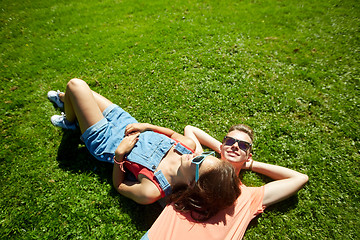 Image showing happy teenage couple lying on grass at summer