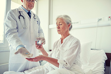 Image showing doctor giving medicine to senior woman at hospital