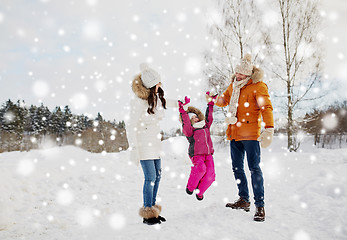 Image showing happy family in winter clothes walking outdoors