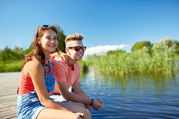 Image showing happy teenage couple sitting on river berth