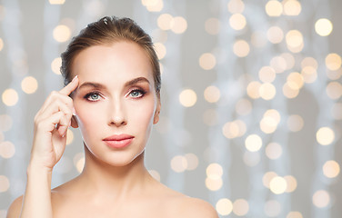 Image showing beautiful woman pointing at her forehead