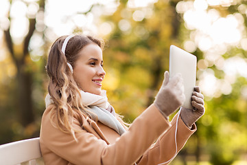 Image showing woman with tablet pc and headphones in autumn park