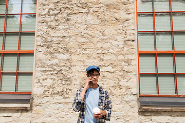 Image showing man with smartphone drinking coffee on city street