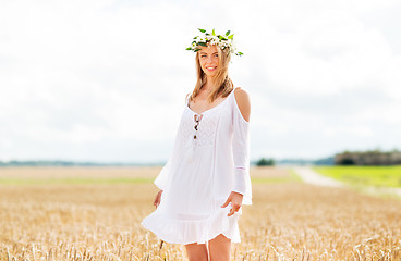 Image showing happy young woman in flower wreath on cereal field