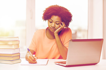 Image showing bored african american woman doing homework home