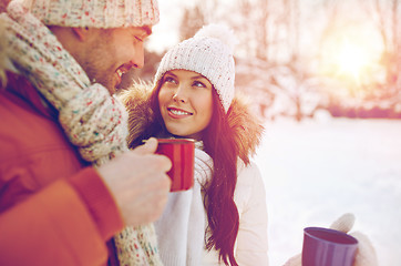 Image showing happy couple with tea cups over winter landscape