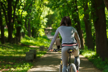 Image showing cyclist woman riding a bicycle in park