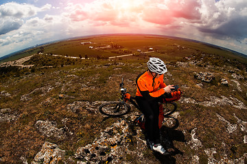 Image showing Young Male Cyclist Talking On Cell Phone