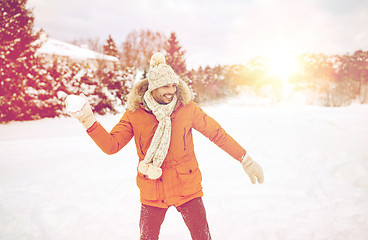 Image showing happy young man playing snowballs in winter