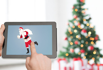 Image showing close up of hands with santa claus on tablet pc