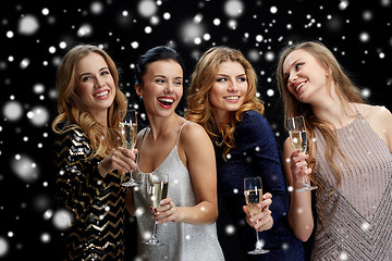 Image showing happy women with champagne glasses over black