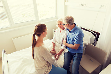 Image showing happy family visiting senior woman at hospital