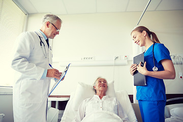 Image showing doctor and nurse visiting senior woman at hospital