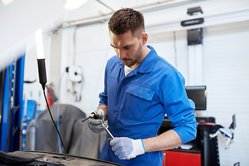 Image showing mechanic man with wrench repairing car at workshop