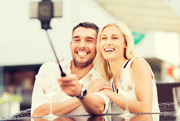 Image showing happy couple taking selfie with smartphone at cafe