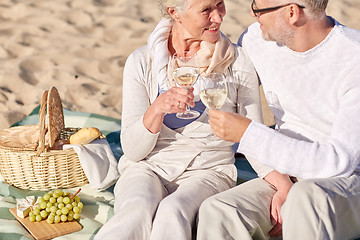 Image showing happy senior couple having picnic on summer beach