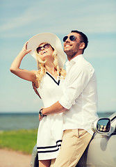 Image showing happy man and woman hugging near car at sea