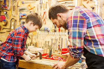 Image showing father and son with hammer working at workshop