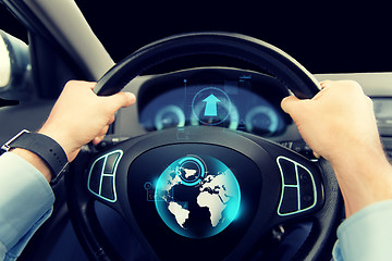 Image showing close up of man driving car with globe on screen