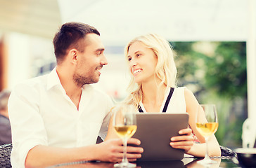 Image showing happy couple with tablet pc at restaurant lounge