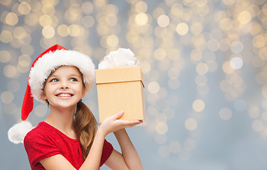 Image showing smiling girl in santa hat with christmas gift box