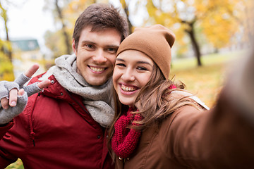 Image showing happy young couple taking selfie in autumn park