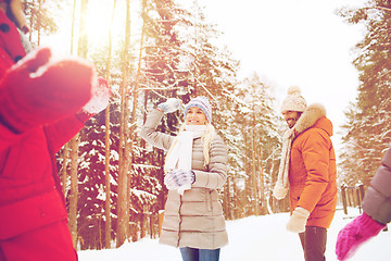 Image showing happy friends playing snowball in winter forest