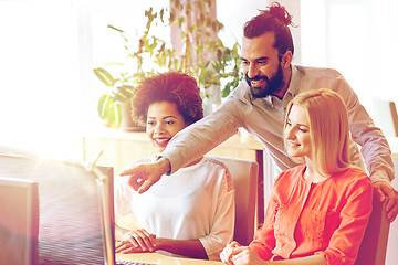 Image showing happy creative team with computer in office