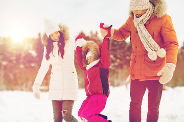 Image showing happy family in winter clothes walking outdoors