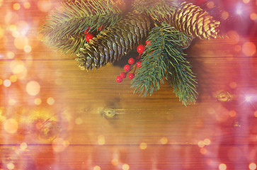 Image showing close up of fir branch with cones on wooden table