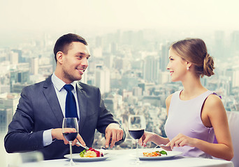 Image showing smiling couple eating main course at restaurant