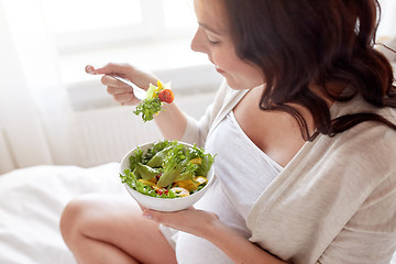Image showing close up of pregnant woman eating salad at home