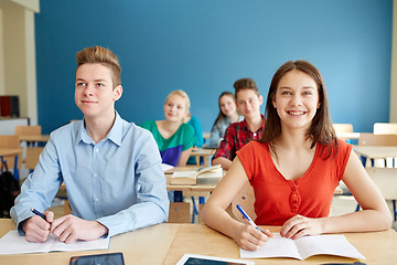 Image showing happy students with notebooks at school