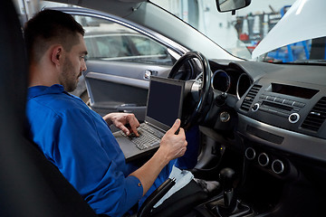 Image showing mechanic man with laptop making car diagnostic