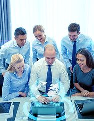 Image showing smiling business people with laptop in office