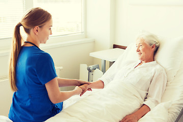 Image showing doctor or nurse visiting senior woman at hospital