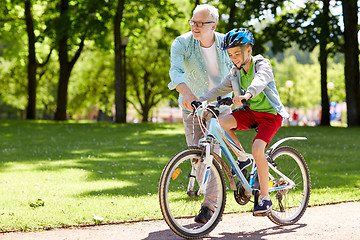 Image showing grandfather and boy with bicycle at summer park