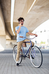 Image showing man with smartphone and fixed gear bike on street