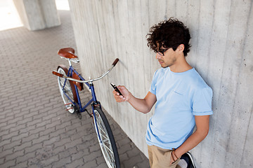 Image showing man with smartphone and fixed gear bike on street