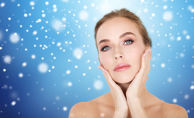 Image showing beautiful woman touching her face over snow